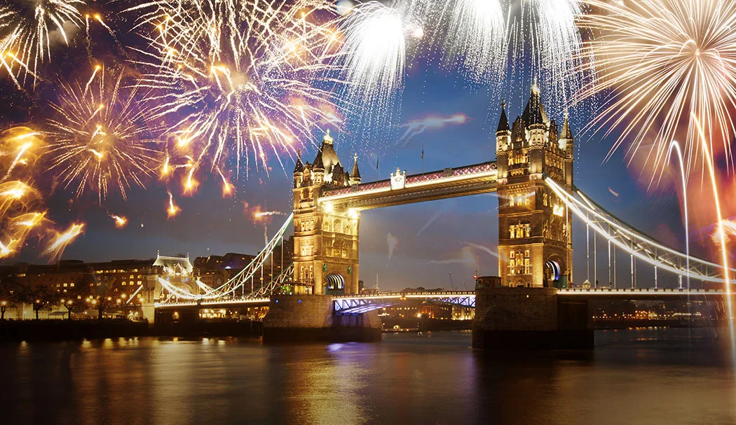 Fireworks illuminating the night sky over Tower Bridge in London, creating a vibrant and celebratory atmosphere for the New Year.