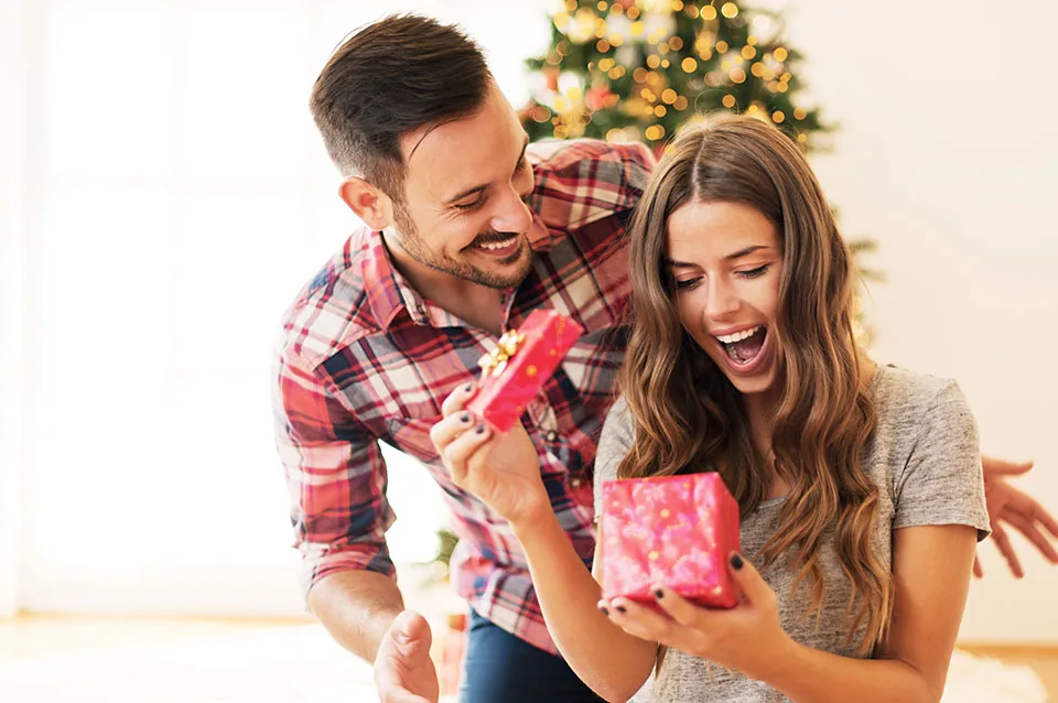Man giving a Christmas present to a young woman