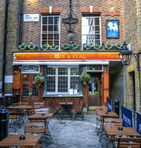 Historic Lamb and Flag pub in Covent Garden, shot from far with street and outdoor tables